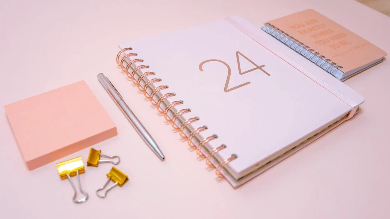 Side-by-side comparison of a budget binder with tabs and a financial notebook on a desk.