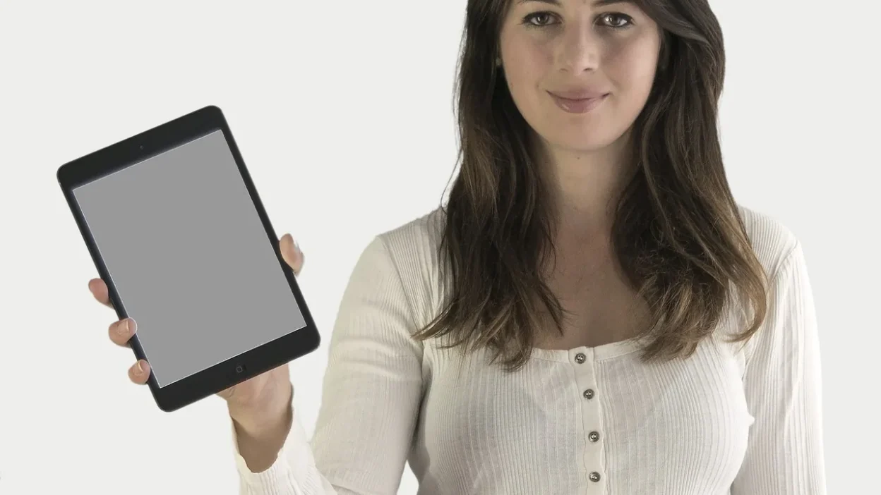 Woman using laptop and mobile app to track monthly budget with colorful charts and graphs