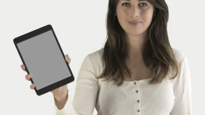 Woman using laptop and mobile app to track monthly budget with colorful charts and graphs