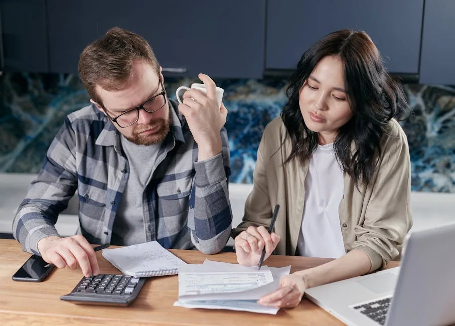 Diverse Couple Reviewing Household Bills And A Checklist On Laptop.