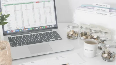 Colorful labeled envelopes and digital spreadsheet for organizing personal budget spending categories and sinking funds